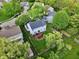 An aerial view showcasing a home's backyard with a wooden deck, a fire pit, and mature trees at 9099 Merrill Ct, Fishers, IN 46038