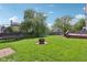 A backyard with a trampoline, fire pit area, wooden deck and well-maintained lawn at 9099 Merrill Ct, Fishers, IN 46038