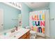 This vibrant bathroom features a Hello Sunshine shower curtain, a modern sink, and bright, cheerful wall color at 9099 Merrill Ct, Fishers, IN 46038