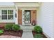 Inviting front door with decorative glass, enhanced by manicured landscaping and charming exterior details at 9099 Merrill Ct, Fishers, IN 46038