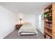 A cozy bedroom is brightly lit with natural light, showcasing a bookshelf filled with plants and books at 9467 Sandpiper W Dr, Indianapolis, IN 46268
