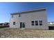 Rear exterior featuring sliding glass doors and neutral siding, providing a clean and modern look to the backyard at 10145 Redwood Peak Ln, Indianapolis, IN 46259