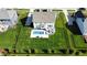 An aerial view shows a backyard with an in-ground swimming pool, patio, and lush green lawn at 1051 Margate Dr, Greenwood, IN 46143