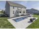 This backyard boasts a sleek pool with integrated fountains, stylish patio, and lush landscaping at 1051 Margate Dr, Greenwood, IN 46143