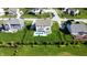 This aerial view shows a fenced-in yard with a pool, patio, and play set surrounded by lush landscaping at 1051 Margate Dr, Greenwood, IN 46143