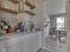 Coffee bar area featuring light grey cabinetry, display shelves and an adjacent breakfast nook with a view of the outdoors at 1051 Margate Dr, Greenwood, IN 46143