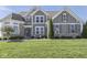 Charming two-story home featuring a stone facade, manicured lawn, and inviting front porch at 1051 Margate Dr, Greenwood, IN 46143