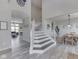 Open foyer showcasing elegant staircase, wood-look floors, and a glimpse of the living and dining areas at 1051 Margate Dr, Greenwood, IN 46143