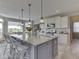 Bright kitchen featuring a gray island with granite counters, white cabinets, pendant lights and stainless appliances at 1051 Margate Dr, Greenwood, IN 46143