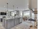 Open kitchen with a large island featuring granite counters, white cabinets, a stainless dishwasher, and modern lighting at 1051 Margate Dr, Greenwood, IN 46143