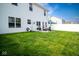 Large backyard featuring a lush green lawn, white fence, and outdoor patio seating at 10538 Rose Mill Dr, Lawrence, IN 46235