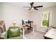 Bedroom with ceiling fan, sit stand desk, a comfy green chair and outdoor view at 10538 Rose Mill Dr, Lawrence, IN 46235