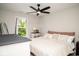 Neutral bedroom with ceiling fan, a side table and a bright window view at 10538 Rose Mill Dr, Lawrence, IN 46235