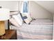 Comfortable bedroom featuring striped bedding, throw pillows and a side table with lamp at 10538 Rose Mill Dr, Lawrence, IN 46235