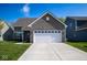 Charming home featuring a gray brick facade, a two-car garage, and a well-manicured lawn at 10538 Rose Mill Dr, Lawrence, IN 46235