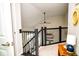 Upstairs hallway with dark rod iron railing and a view of the staircase and entry below at 10538 Rose Mill Dr, Lawrence, IN 46235