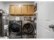 Laundry room with upper cabinets, modern washer & dryer, and storage space at 106 W Delaware St, Fortville, IN 46040