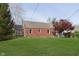 Spacious backyard with mature landscaping including a large lawn and brick house at 10745 Southeastern Ave, Indianapolis, IN 46239