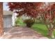 Well-maintained backyard with a red brick patio, lush lawn, and colorful trees at 10745 Southeastern Ave, Indianapolis, IN 46239