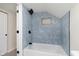 Modern bathroom featuring a bathtub with blue vertical tiles and a rainfall shower head at 10745 Southeastern Ave, Indianapolis, IN 46239
