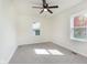 Bright bedroom with new carpet, a ceiling fan, and natural light from the double-paned windows at 10745 Southeastern Ave, Indianapolis, IN 46239