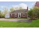 Lovely brick home showcasing a lush green lawn and a detached garage on a sunny day at 10745 Southeastern Ave, Indianapolis, IN 46239