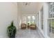 Relaxing sunroom featuring brick wall, tile floors, wicker furniture, and natural light at 10745 Southeastern Ave, Indianapolis, IN 46239