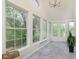 Bright sunroom with large windows offering views of lush greenery, tile flooring, and modern lighting at 10745 Southeastern Ave, Indianapolis, IN 46239