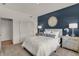Bedroom with a navy accent wall, white bedding, and minimalist decor at 10805 Soda Creek Ct, Indianapolis, IN 46239