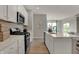 Bright kitchen featuring white cabinets, stainless steel appliances and an island with quartz countertop at 10805 Soda Creek Ct, Indianapolis, IN 46239