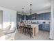 Beautiful kitchen features gray cabinets, stainless appliances, an island with bar seating and pendant lighting at 1087 Stubble Run, Danville, IN 46122