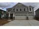 A two-story home with gray siding, stone accents, a two-car garage and a concrete driveway at 12417 Fresh Stock Dr, Noblesville, IN 46060