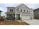 A two-story home with gray siding, stone accents, a two-car garage and a concrete driveway at 12417 Fresh Stock Dr, Noblesville, IN 46060