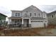 New two-story home with gray siding, stone accents, covered porch, and two-car garage awaiting its landscaping at 12417 Fresh Stock Dr, Noblesville, IN 46060