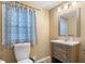 This bathroom has a toilet, sink and cabinet with a window at 12449 Huntington Dr, Indianapolis, IN 46229