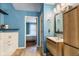 Stylish bathroom with a wood vanity, large mirror, and a glimpse of the adjacent bedroom at 12449 Huntington Dr, Indianapolis, IN 46229