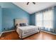 Bright bedroom with blue walls, wood floors, and a large bed at 12449 Huntington Dr, Indianapolis, IN 46229
