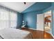 Bedroom featuring wood floors, blue walls, and baby swing at 12449 Huntington Dr, Indianapolis, IN 46229