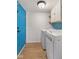 Bright laundry room featuring modern washer and dryer, blue backsplash, storage cabinets, and a vibrant blue door at 12449 Huntington Dr, Indianapolis, IN 46229