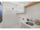Well-lit laundry room with marble-style tile floor, sink, and white cabinets at 1285 Chatham Hills Blvd, Westfield, IN 46074
