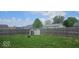 Expansive backyard featuring a secure wood fence and a practical storage shed on a well-maintained lawn at 1370 Ash Ct, Martinsville, IN 46151