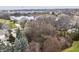 Aerial view captures a neighborhood near a tranquil lake, dotted with houses among mature trees and lush greenery at 13855 Waterway Blvd, Fishers, IN 46040