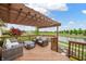 Cozy deck with pergola overlooking a serene water view at 14145 Charity Chase Cir, Carmel, IN 46074