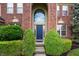 Inviting home featuring a stately brick facade and manicured bushes framing the blue front door at 14145 Charity Chase Cir, Carmel, IN 46074