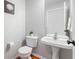 Small powder room with hardwood floors, pedestal sink, and wallpaper at 14145 Charity Chase Cir, Carmel, IN 46074