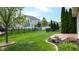 Lush green backyard with stone patio and garden beds, perfect for outdoor enjoyment and landscaping at 1435 Colony Park Dr, Greenwood, IN 46143