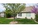 Backyard with well-maintained lawn, tree landscaping, patio, and exterior of the home's back at 1435 Colony Park Dr, Greenwood, IN 46143