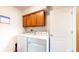 Functional laundry room includes washer, dryer, storage cabinets and white door, designed for convenience at 1435 Colony Park Dr, Greenwood, IN 46143