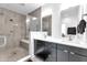 Modern bathroom with double vanity, glass-enclosed shower with bench, and neutral tile; offering a spa-like experience at 1702 Alvord St, Indianapolis, IN 46202