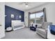 Charming Bedroom with a white crib, cozy armchair, and a blue accent wall, creating a comforting space at 1702 Alvord St, Indianapolis, IN 46202